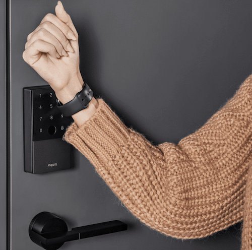 woman unlocking smart door lock with smartwatch