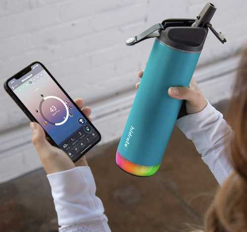 woman with smart water bottle and smartphone